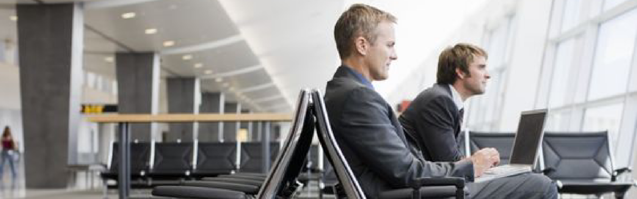 Deber de diligencia: Responsabilidad compartida entre viajeros y gestores de viajes 7 two man waiting for their plane in the airport, meanwhile they work.